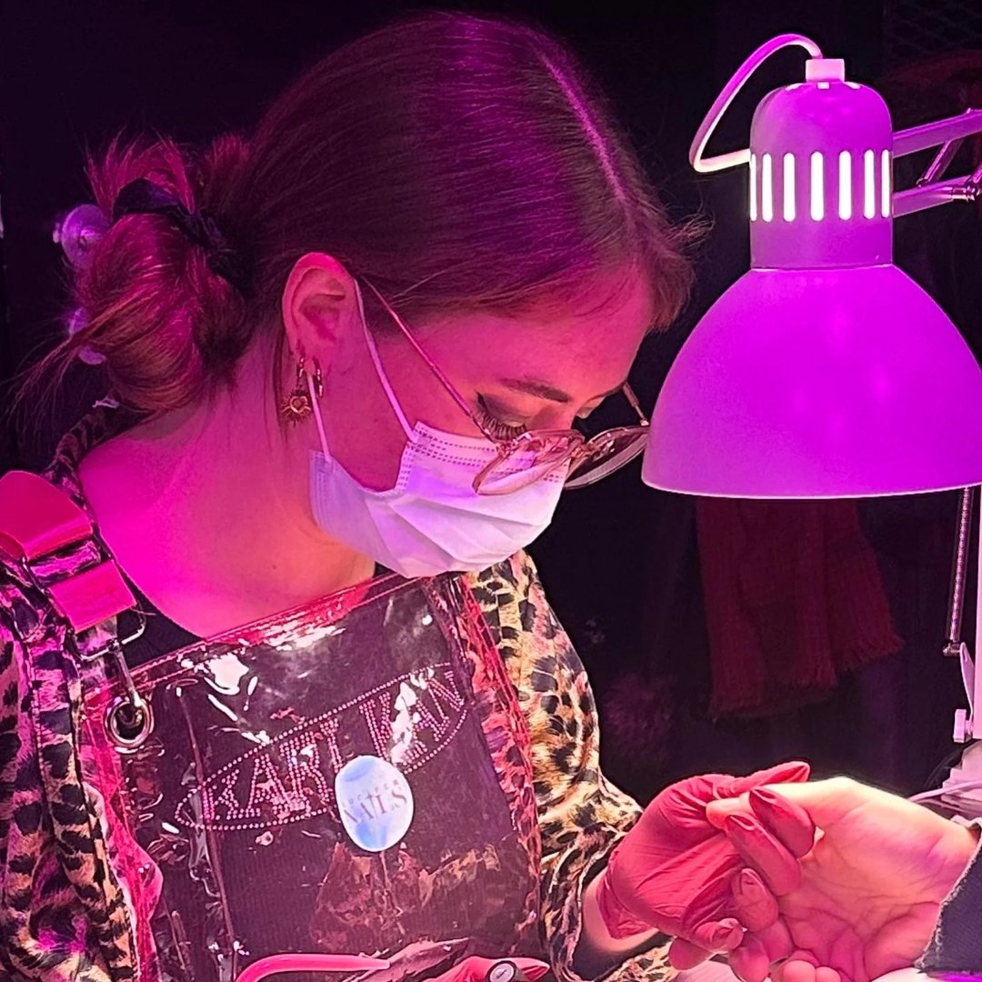 Lucifer Nails Atelier — Arbeit am Nageldesign unter pinker Lampe